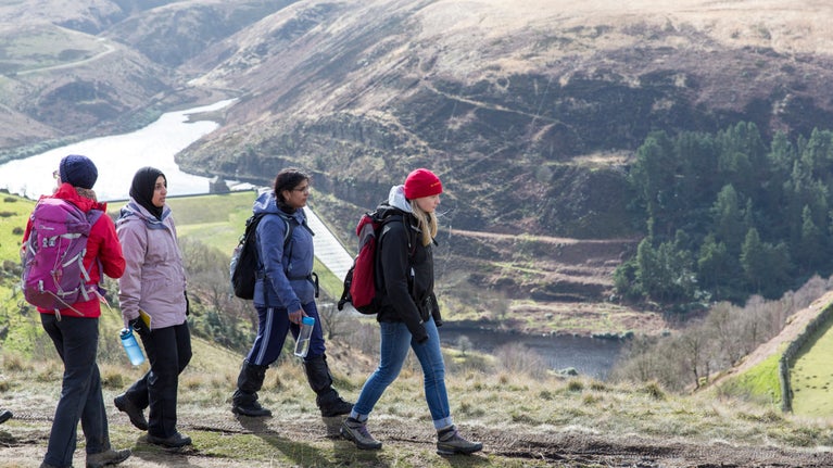 A group of winter hikers with view over a reservoir in the distance
